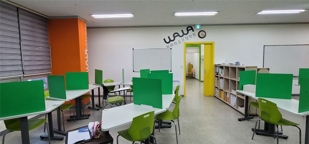 비전점 교실 — 개인 칸막이 책상과 화이트보드가 있는 학습 공간