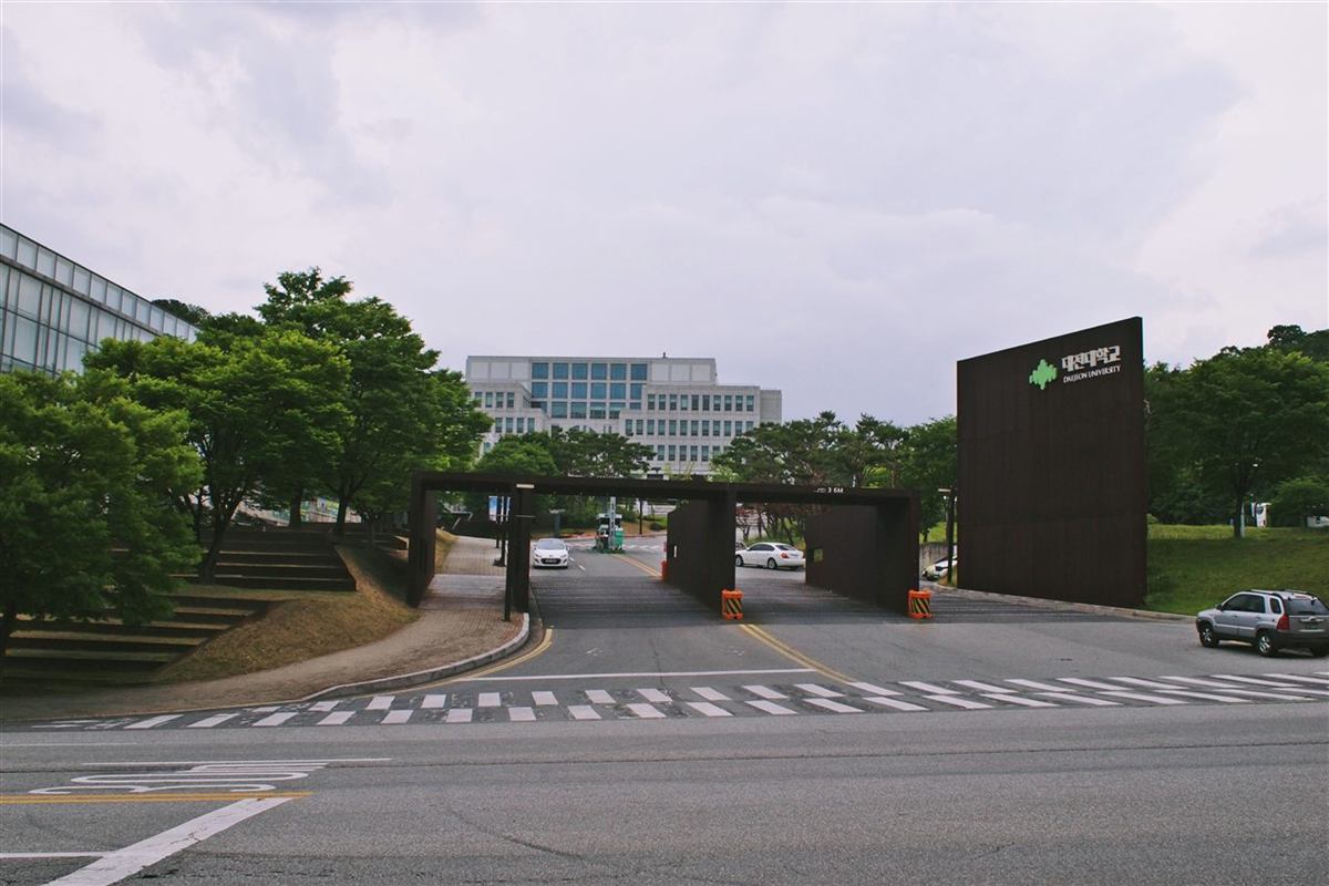 대전 동구 용운동 대전대학교 정문 — 갈색 철제 게이트와 대전대학교 표지석, 뒤로 보이는 캠퍼스 건물