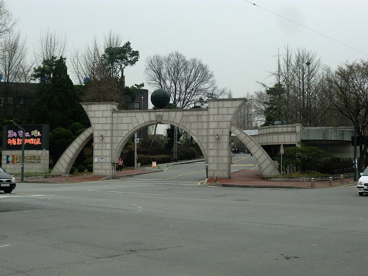한경국립대학교 안성캠퍼스 정문 — 아치 모양의 돌문과 그 위에 놓인 조형물, 왼쪽에 학교 안내 전광판이 보이는 모습