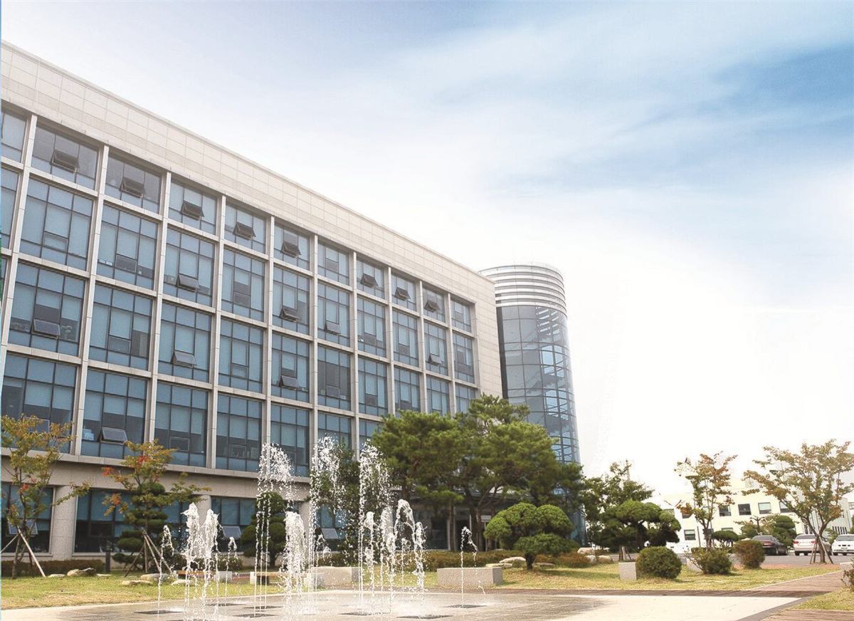 한국항공대학교 본관 건물 — 넓은 잔디 광장 뒤로 좌우 대칭의 석조 본관이 서 있고, 가운데에 기둥이 늘어선 현관이 있다